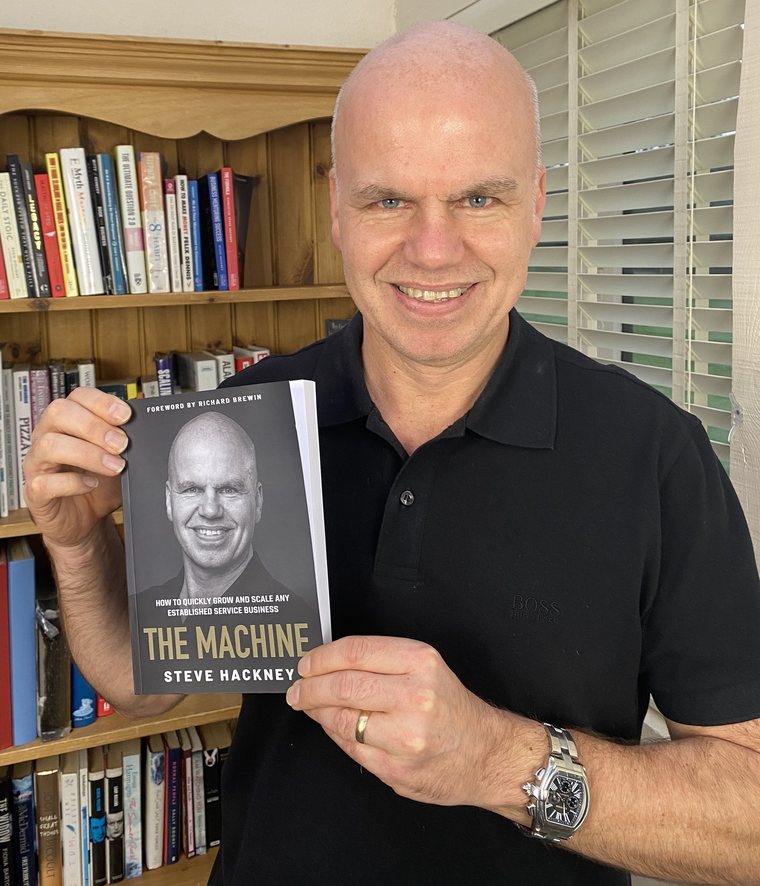 Steve Hackney holding his published book, The Machine